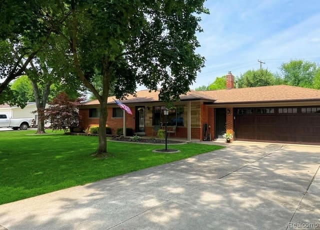 Front exterior with wide concrete driveway and attached two-car garage