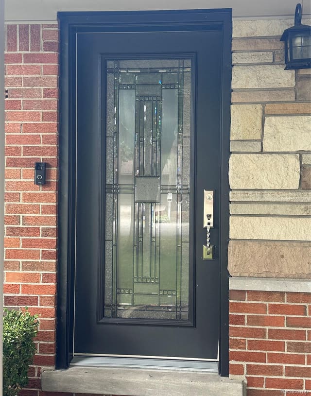 Leaded-glass front entry door with brick and stone surround