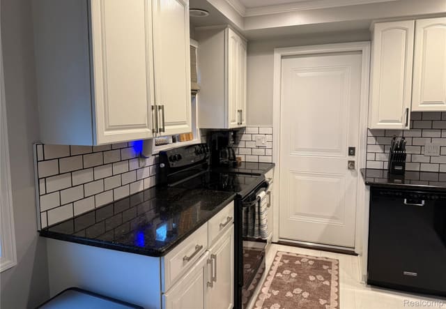 Granite counter run with subway-tile backsplash and white cabinets
