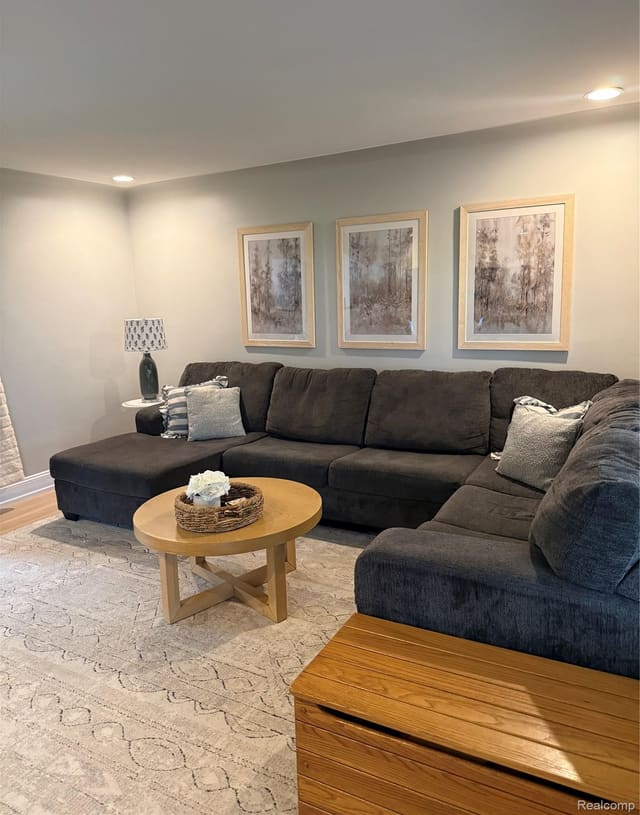 Living room sectional beneath a trio of framed prints