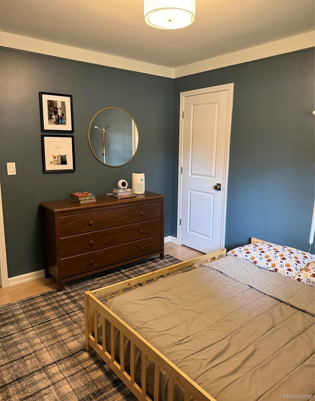 Second bedroom with dresser and round mirror