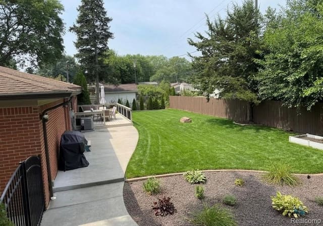 Landscaped backyard walkway with garden beds